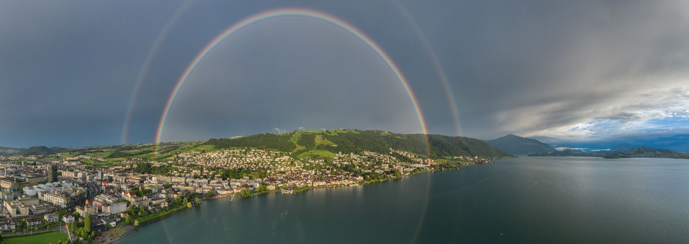 Panorama: Doppelter Regenbogen über Zug und dem Zugerberg